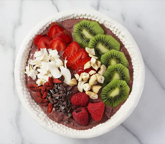 Cacao smoothie bowl topped with fresh fruit and Navitas Organics Cacao Nibs