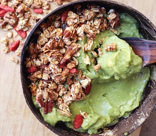 Nutty granola sprinkled over an avocado smoothie bowl