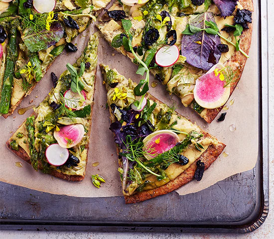 Dairy-free pizza topped with radishes, greens, and white bean puree