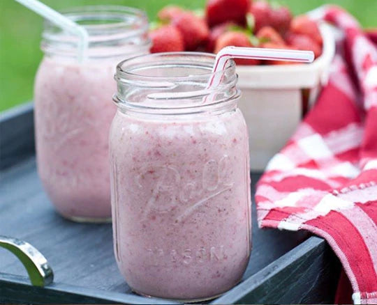 Ball jars filled with a light pink strawberry chia seed smoothie