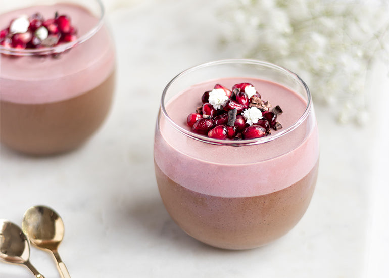 Chocolate Pomegranate panna cotta cups made with Navitas Organics Cacao+ Antioxidant Blend and Pomegranate Powder, topped with pomegranate seeds and Navitas Organics Cacao Nibs