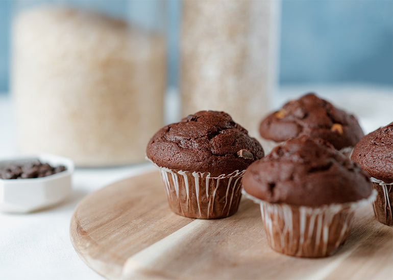Chocolate muffins made with Navitas Organics Cacao Powder and Cacao Nibs on a wooden board