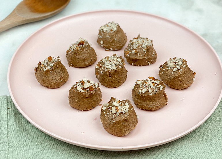 A plate full of keto chocolate fat bombs made with Navitas Organics Cacao Powder and Cacao Butter Wafers