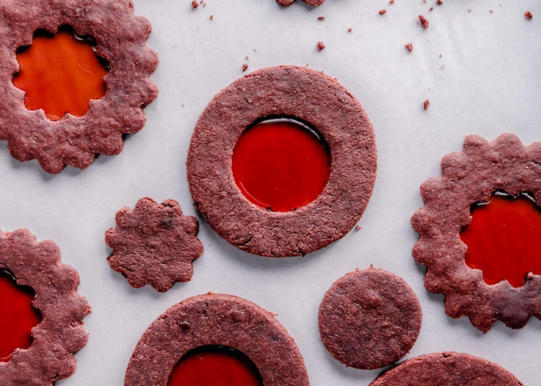 Chocolate cookies made with Navitas Organics Cacao Powder with stained glass-like centers made with Navitas Organics Pomegranate Powder