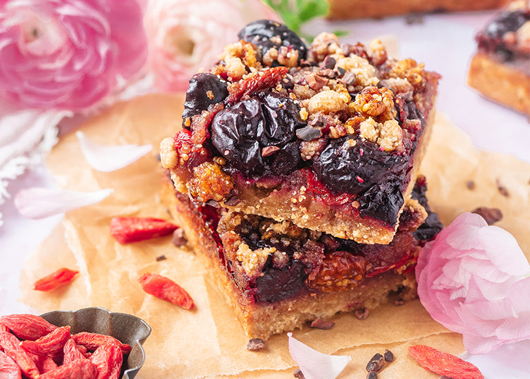 A stack of berry crumble squares made with Navitas Organics Grain-Free Flour, cherries and Navitas Organics Goji Berries and Goldenberries
