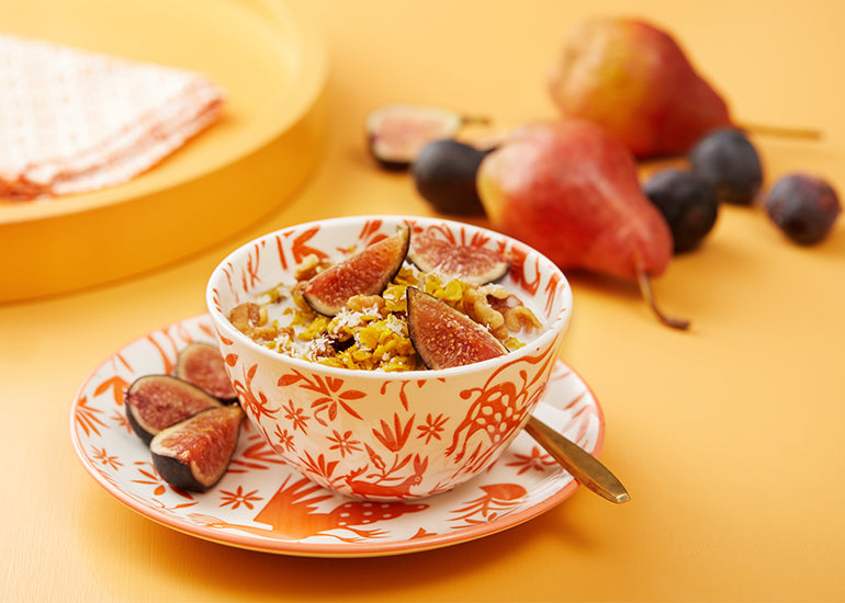 A bowl of oatmeal made with Navitas Organics Turmeric Powder and Mulberries, topped with fresh figs