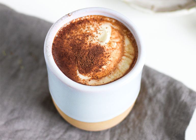 A ceramic mug filled with keto hot chocolate made with Navitas Organics Keto Cacao Powder