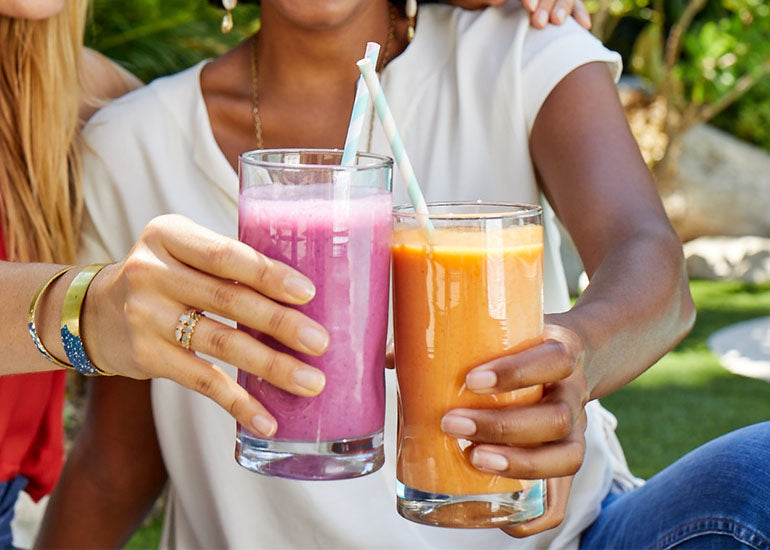 Two women holding smoothies made with Navitas Organics Superfood+ Immunity Blend and Hemp Seeds