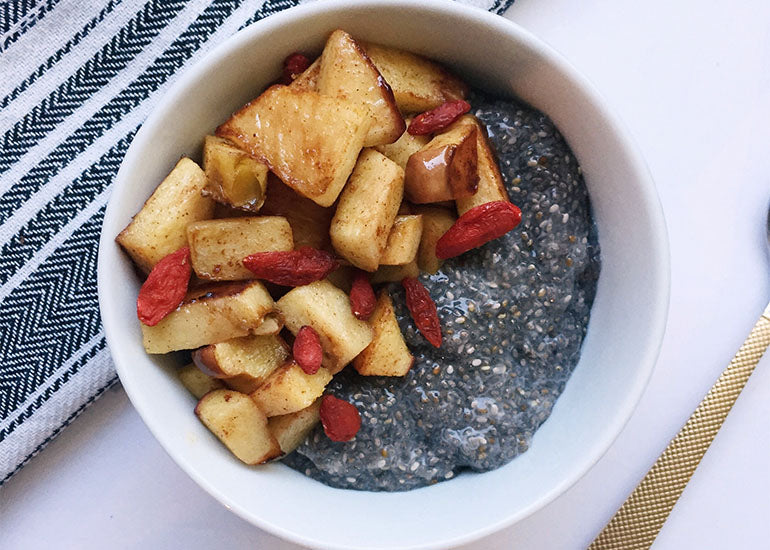 A bowl of chia pudding made with Navitas Organics Chia Seeds, topped with apple compote and Navitas Organics Goji Berries.