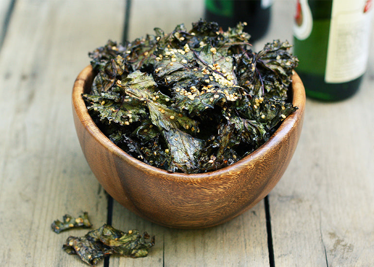 A wooden bowl filled with barbecue hemp kale crisps made with Navitas Organics Hemp Seeds.