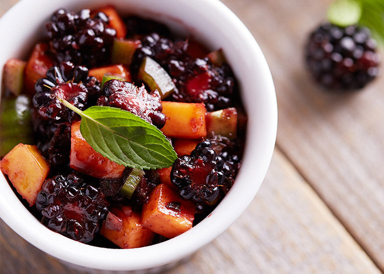 A dish filled with fruit salsa mixed with a sauce made with Navitas Organics Acai Powder.