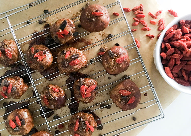 A cooling rack topped with chocolate cashew superfood bites made with Navitas Organics Cashew Nuts, Chia Seeds, Mulberries, Goji Berries, Maca Powder, and Cacao Sweet Nibs