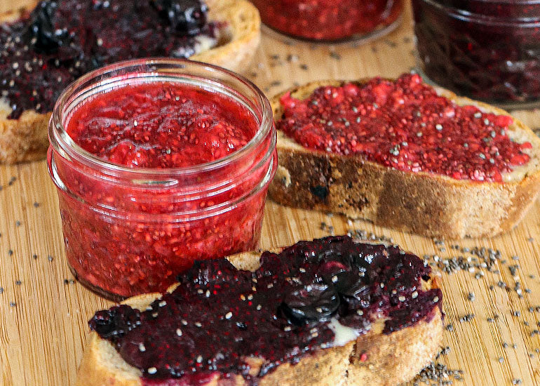 A small jar filled with berry chia jam and slices of toast topped with berry chia jam all made with Navitas Organics Chia Seeds, Pomegranate Powder and Acai Powder