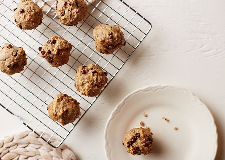 A cooling rack topped with chocolate chip banana muffins made with Navitas Organics Maca Powder and Hemp Seeds.