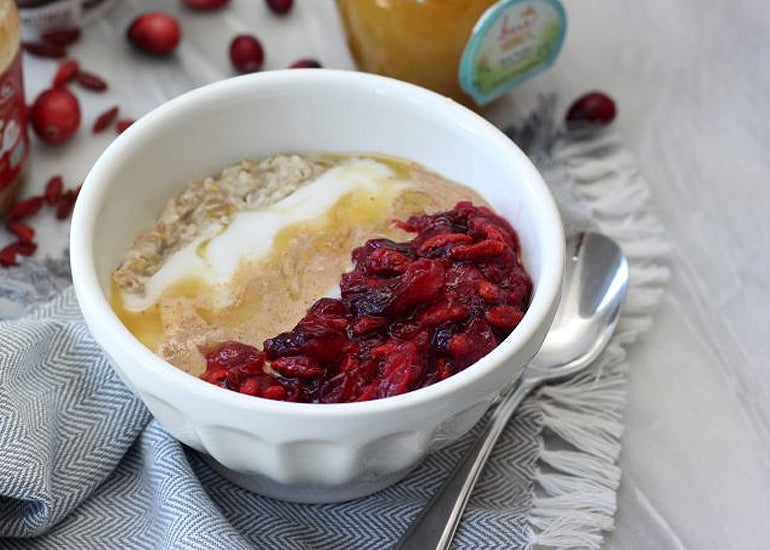 A bowl of creamy superfood oatmeal made with Navitas Organics Goji Berries, Gelatinized Maca Powder, Chia Seeds and Hemp Seeds.