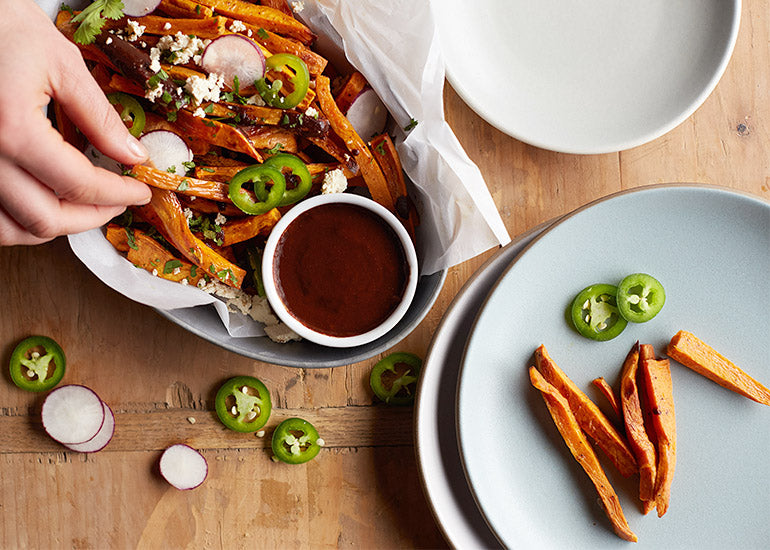 A plate of sweet potato fries served with an acai chili sauce made with Navitas Organics Acai Powder.