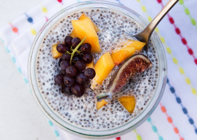 A glass filled with chia pudding made with Navitas Organics Chia Seeds, topped with fresh fruit.