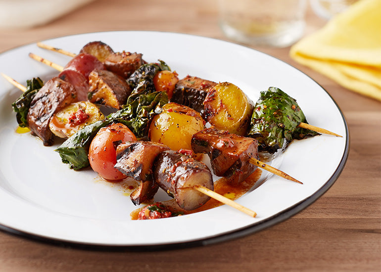 Marinated mushroom kabobs made with Navitas Organics Goji Berries laid out on a plate.
