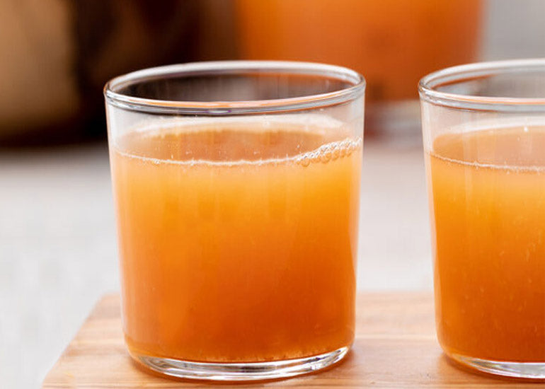 Two vitamin C super shots made with Navitas Organics Camu Powder in glasses.