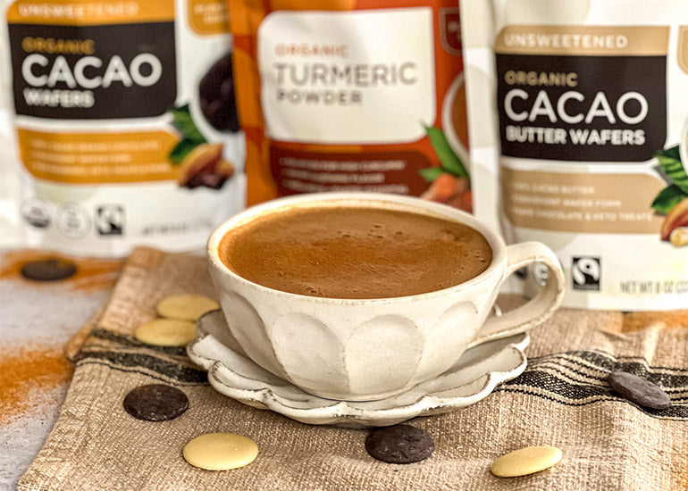 A mug filled with Turmeric Hot Chocolate made with Navitas Organics Cacao Wafers, Cacao Butter Wafers and Turmeric Powder.