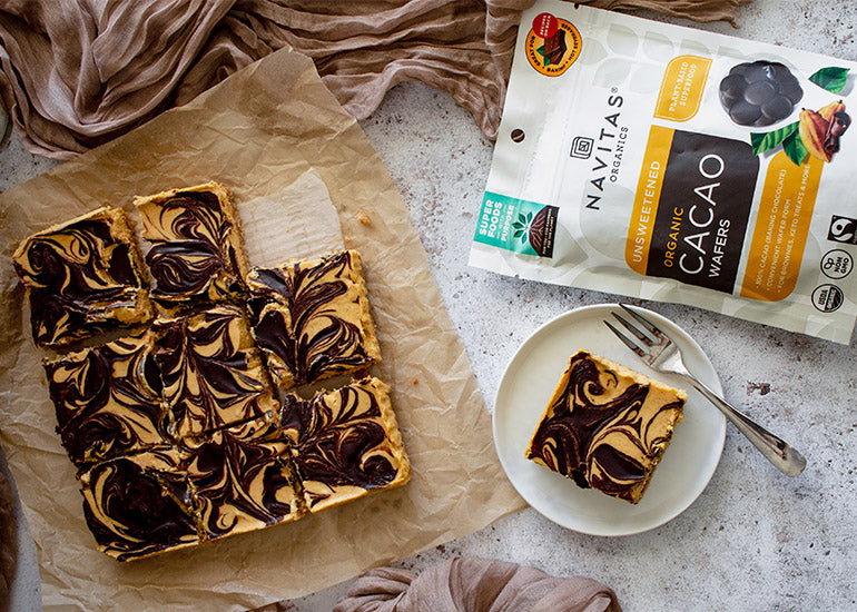 Chocolate-swirled pumpkin cheesecake bars made with Navitas Organics Cacao Wafers.