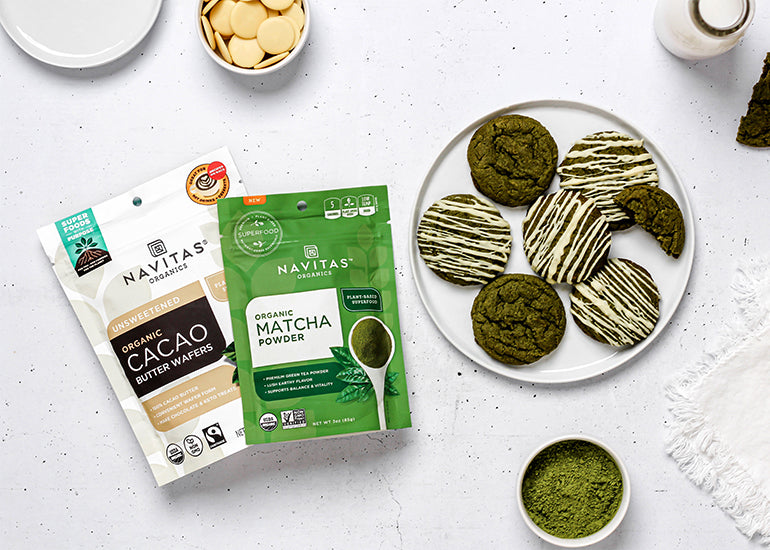 A plate of Matcha Cookies with a white chocolate drizzle made with Navitas Organics Matcha Powder and Cacao Butter Wafers.