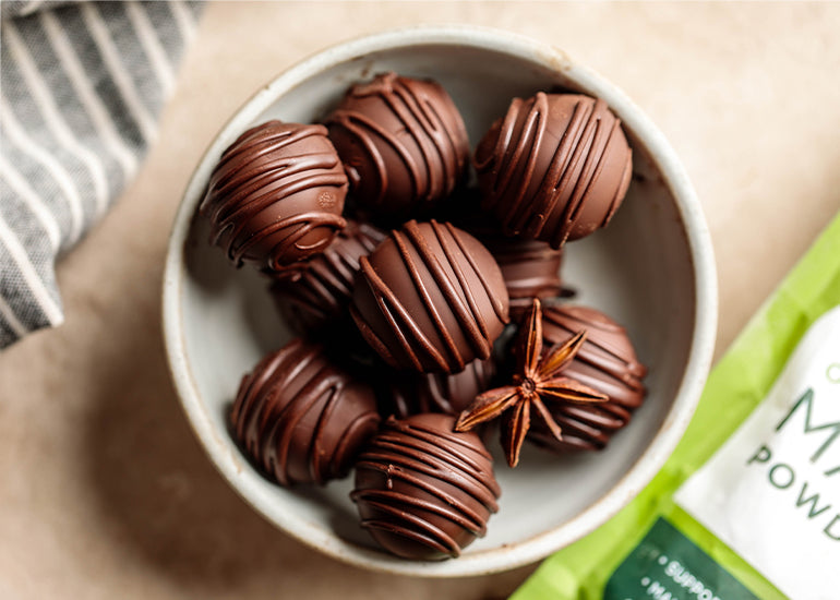 A bowl of chai-spiced chocolate truffles made with Navitas Organics Cacao Powder and Maca Powder.