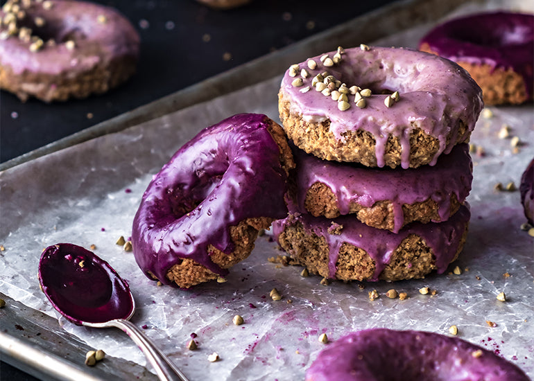 A pan of donuts glazed with Navitas Organics Maqui Powder.