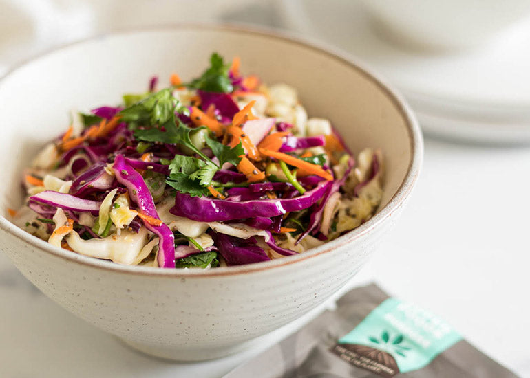 A bowl of coleslaw mixed with a dairy-free dressing made with Navitas Organics Chia Seeds