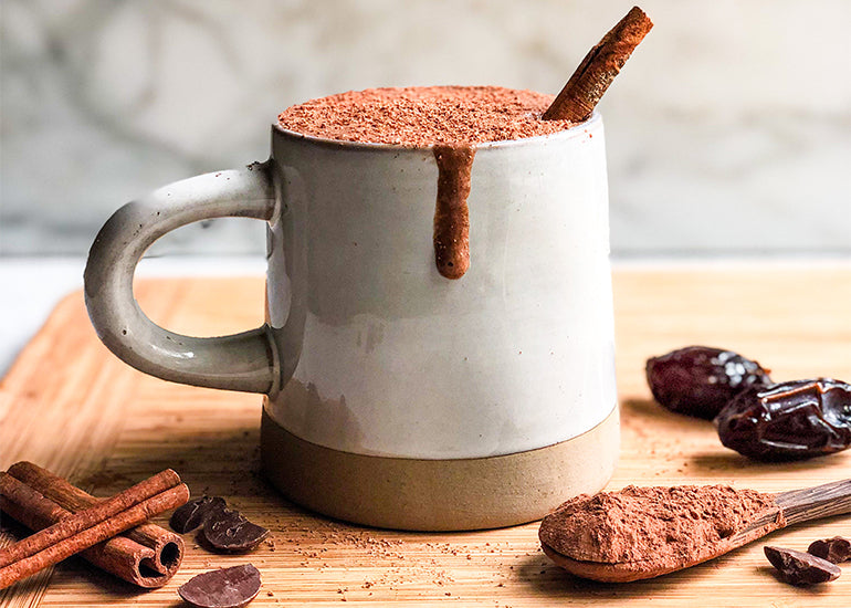 A mug filled with chai-spiced hot chocolate made with Navitas Organics Cacao Powder and Semi-sweet Cacao Wafers.