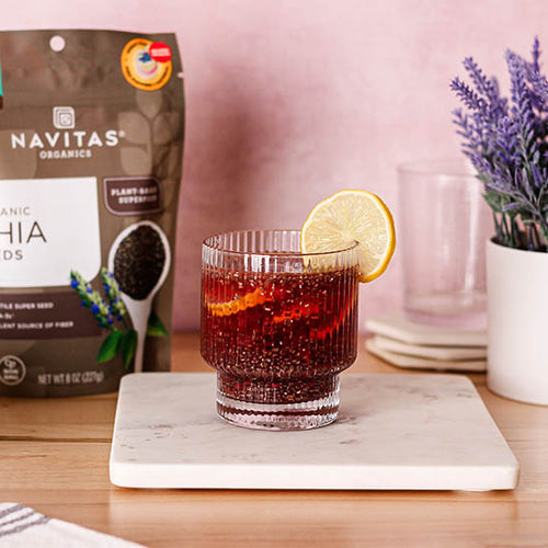 A glass filled with a chia berry fresca made with Navitas Organics Chia Seeds, garnished with lemon slices