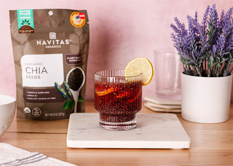 A glass filled with a chia berry fresca made with Navitas Organics Chia Seeds, garnished with lemon slices
