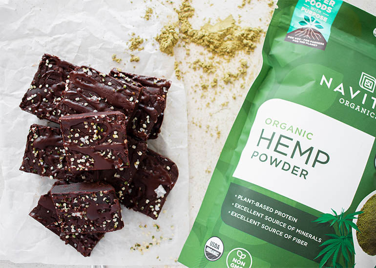 A stack of cacao hemp freezer fudge squares made with Navitas Organics Cacao Powder and Hemp Powder, topped with Navitas Organics Hemp Seeds
