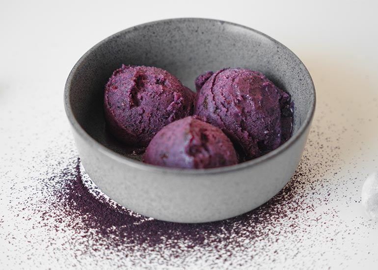 A bowl filled with three scoops of grape and acai nice cream made with Navitas Organics Acai Powder