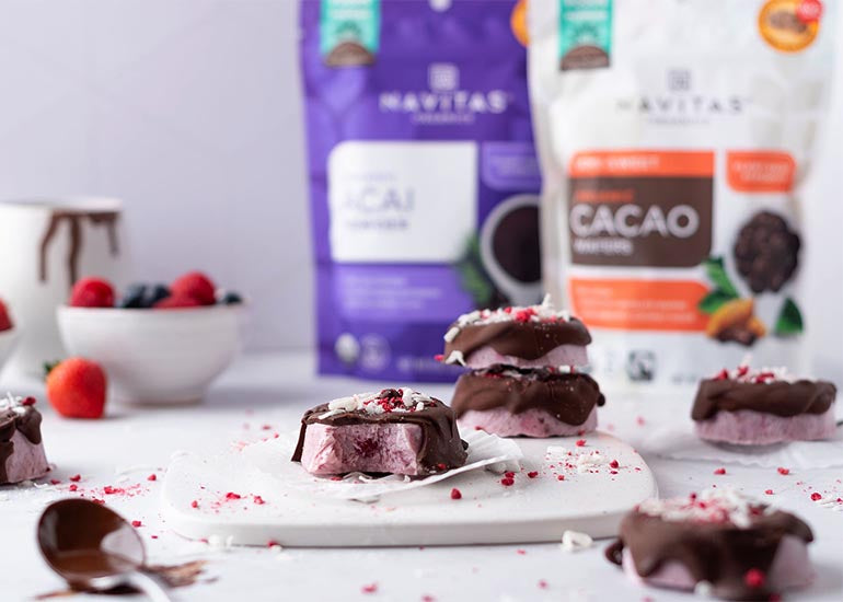 A cutting board topped with acai yogurt bites made with Navitas Organics Acai Powder, drizzled with a chocolate coating made with Navitas Organics Semi-sweet Cacao Wafers