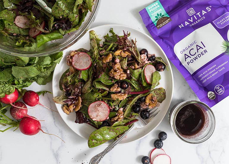 A spring salad topped with an acai vinaigrette dressing made with Navitas Organics Acai Powder