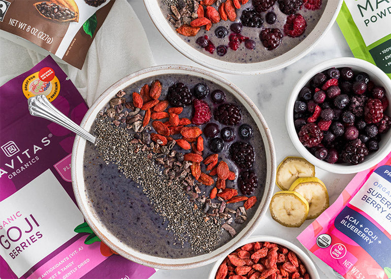 A smoothie bowl made with Navitas Organics Superfood+ Berry Blend and Maca Powder, topped with Navitas Organics Chia Seeds, Goji Berries and Cacao Nibs