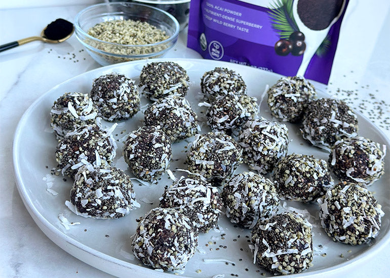 A plate filled with acai energy bites made with Navitas Organics Acai Powder, coated in Navitas Organics Hemp Seeds and Chia Seeds and shredded coconut