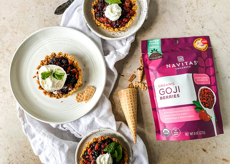 Three plates topped with goji berry tarts made with a sugar cone crust and filled with a berry mixture made with Navitas Organics Goji Berries