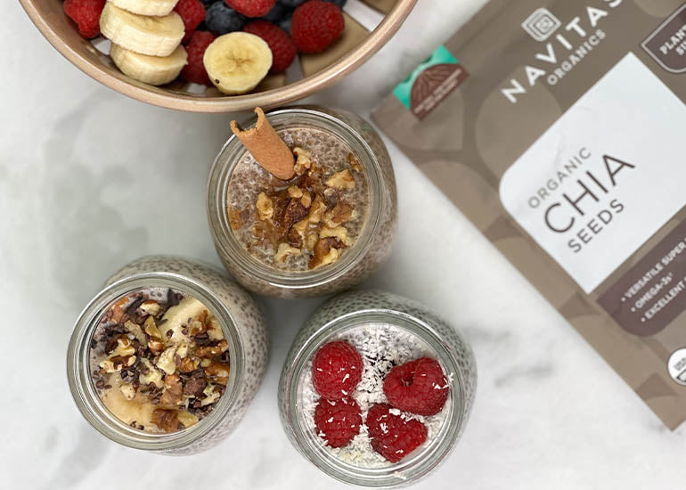 Three jars filled with different varieties and flavors of chia pudding made with Navitas Organics Chia Seeds, topped with different superfood toppings