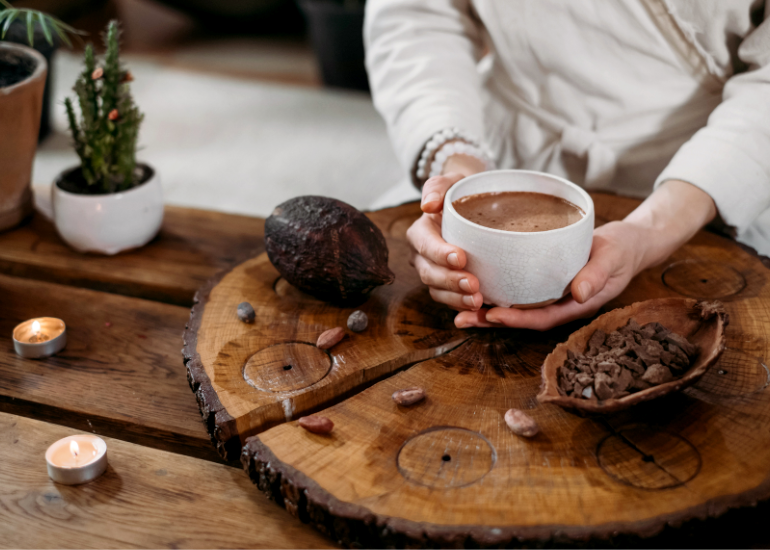 A woman holding a mug filled with hot chocolate made with Navitas Organics Fairtrade Certified Cacao.
