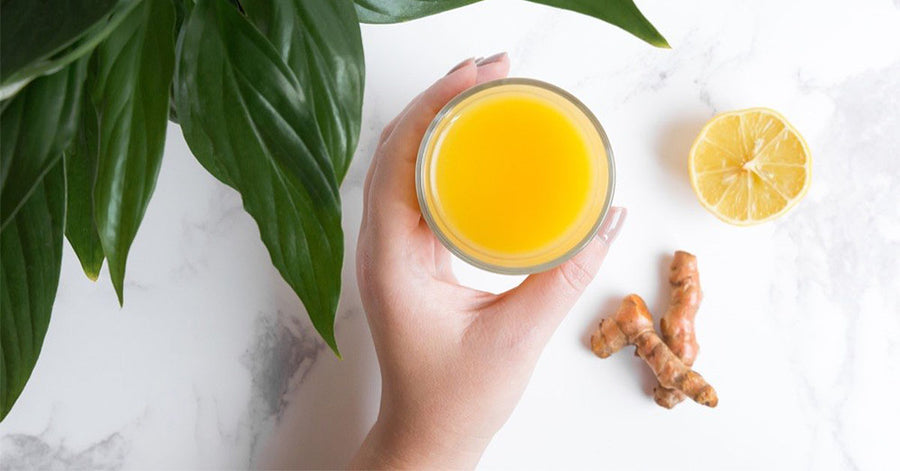 A woman holding a cup of tea made with Navitas Organics Turmeric Powder