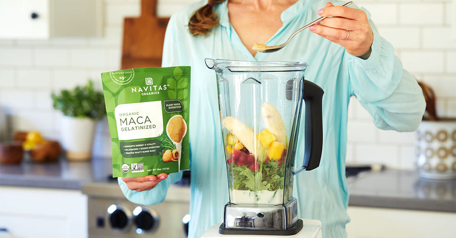 A woman making a smoothie with Navitas Organics Gelatinized Maca Powder.
