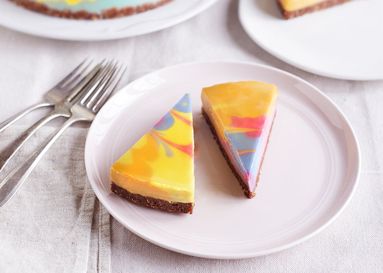 Slices of cheesecake marbled with natural food colorings made from Navitas Organics Superfood Powders.