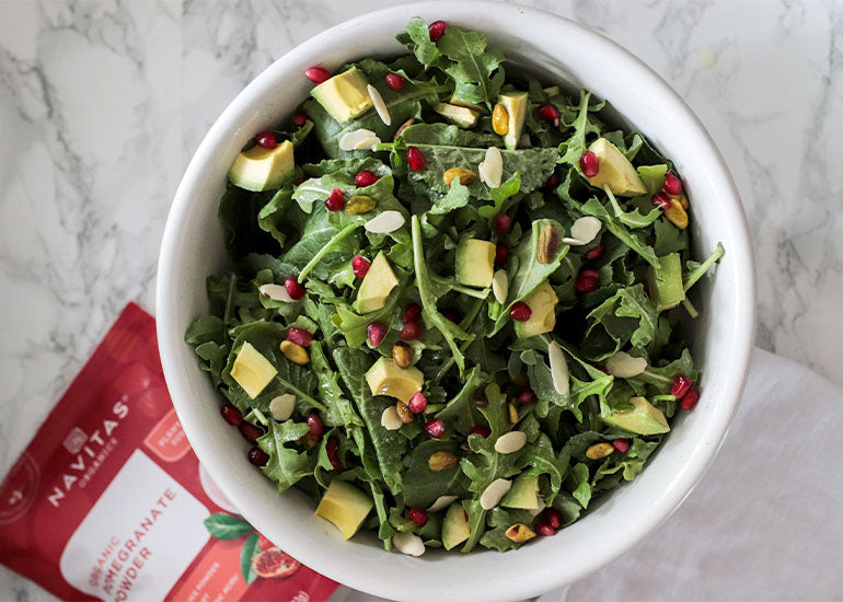 A mixed green salad drizzled with a vinaigrette made with Navitas Organics Pomegranate Powder