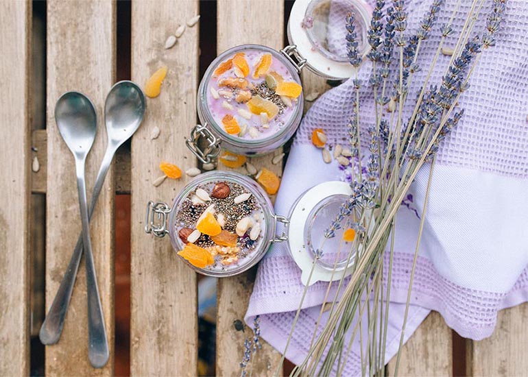 Two chia puddings made with Navitas Organics Chia Seeds with spoons and lavender on a wooden table