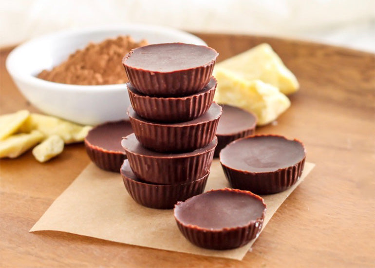 A stack of chocolate cups made with Navitas Organics Cacao Butter and Cacao Powder