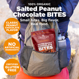 Advertisement for Navitas Organics Salted Peanut Chocolate Bites showing a pack of the product in the back pocket of a hiker's backpack. Features claims of organic ingredients, big flavor, and no artificial ingredients, certified gluten-free.