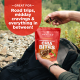 Navitas Organics Superfood+ Strawberry Peanut Chia BITES package held by a person outdoors.