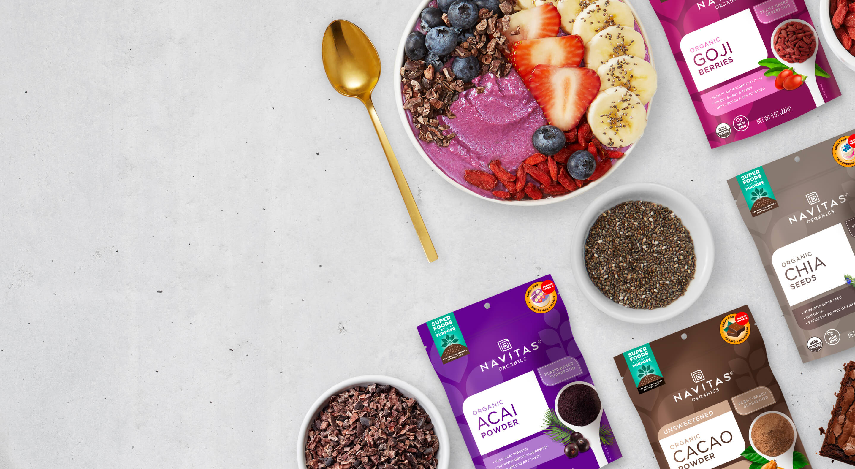 A selection of Navitas Organics superfoods with a smoothie bowl, chia seeds and cacao nibs